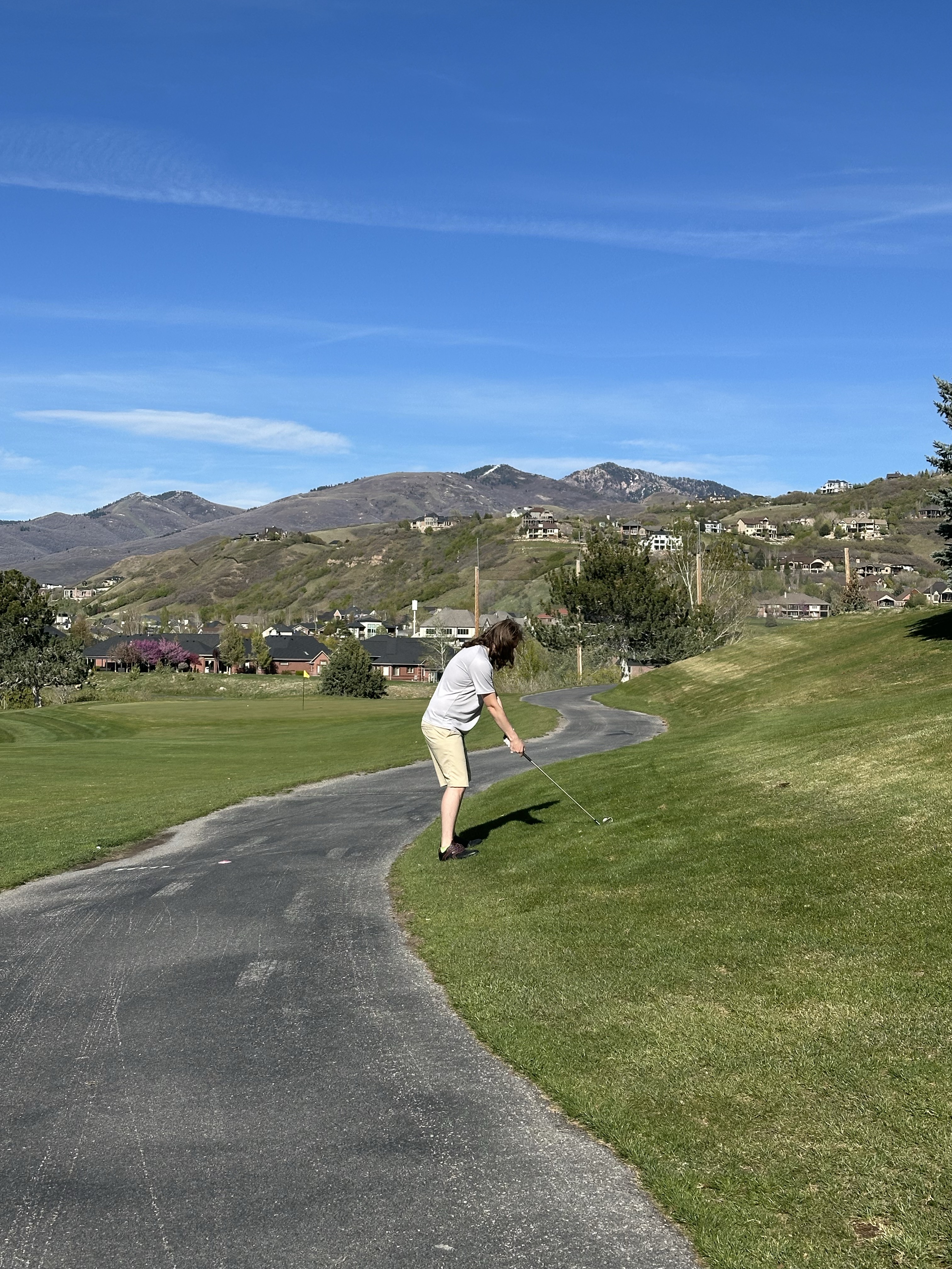 Stockton teeing off on a Utah golf course with mountains in the background